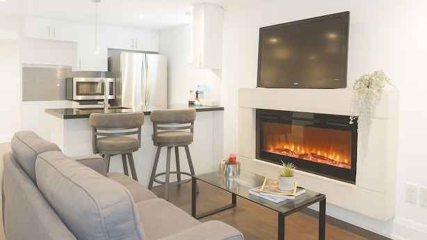 A modern living room with a fireplace, a sofa, and a coffee table. - Comfortable Mississauga Stay, Private Entry, Laundry & Wi-Fi (Mississauga)