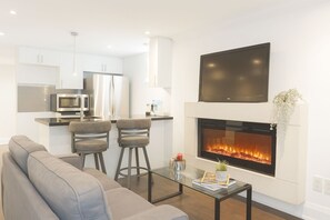 A modern living room with a fireplace, a sofa, and a coffee table. - Comfortable Mississauga Stay, Private Entry, Laundry & Wi-Fi (Mississauga)