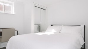 A minimalist bedroom with a large bed, a desk, and a wardrobe. - Comfortable Mississauga Stay, Private Entry, Laundry & Wi-Fi (Mississauga)