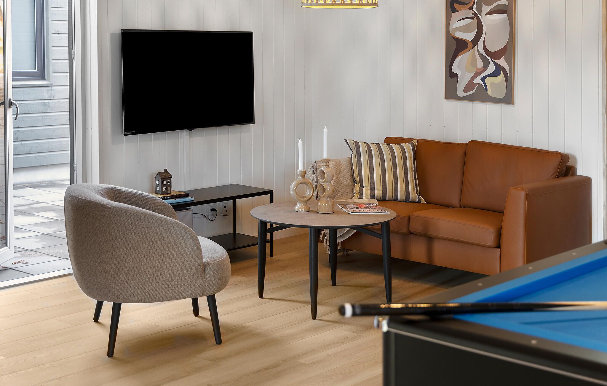 Ein Wohnzimmer mit Sofa, Sesseln, Couchtisch und Billardtisch.