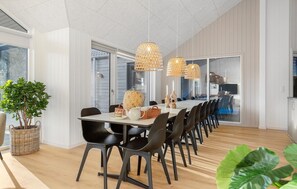A dining area with a long table, black chairs, wicker baskets, and a potted plant. - Cozy home in Glesborg with sauna (Glesborg)