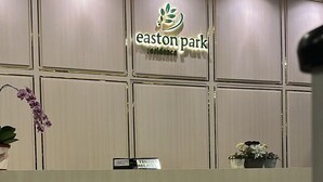 Ein Empfangsschalter mit dem Logo 'easton park residence', einem Schild mit der Aufschrift 'TENANT RELAX' und einer Topfpflanze.
