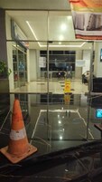 Un vestíbulo moderno con puertas de vidrio, un letrero de piso mojado y un cartel de construcción.