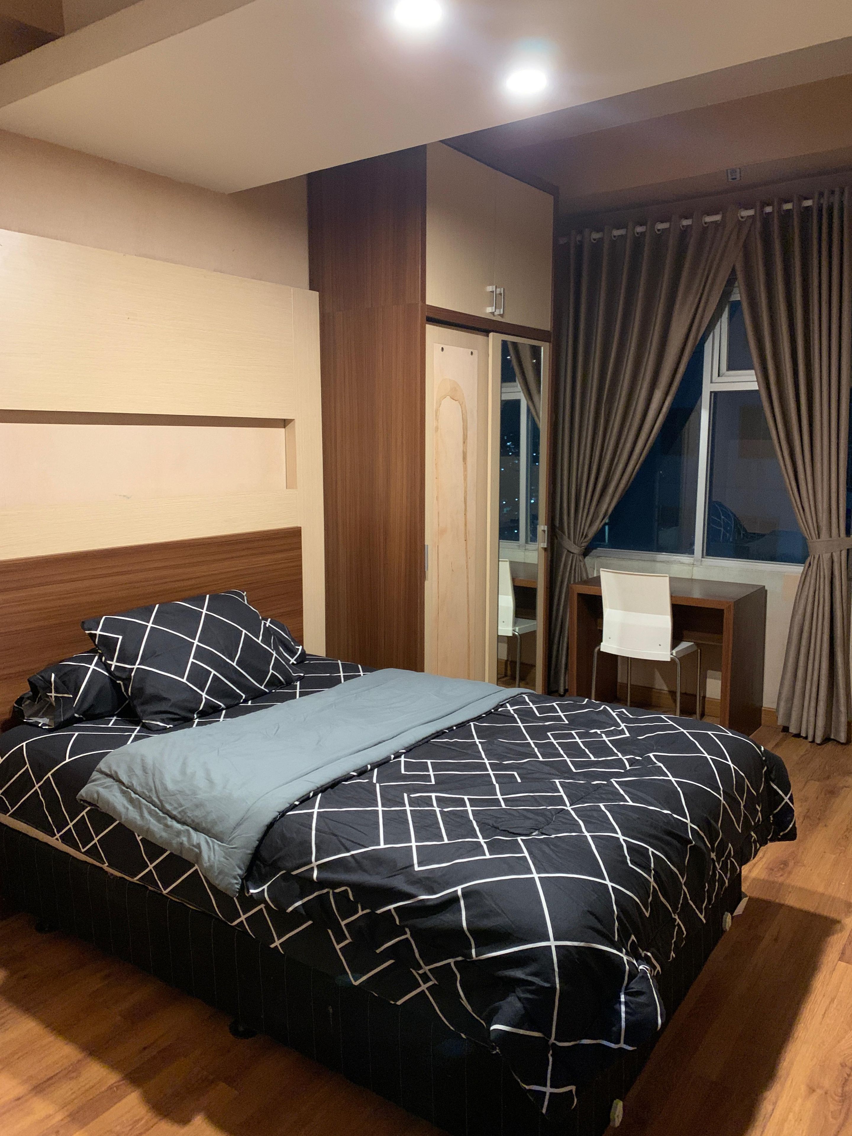 Un dormitorio con una cama, un escritorio y una silla.