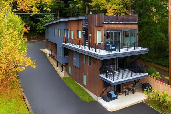 A modern two-story house with a balcony, a staircase, and a small outdoor seating area. - Bayview Modern Luxury by the Lake (Bellevue)