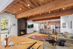 A spacious living area with a fireplace, a dining table, and a sofa.