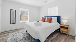 A bedroom with a bed, bedside table, and a mirror. - Family Getaway: Pet Friendly • Close to Downtown (St. Augustine)