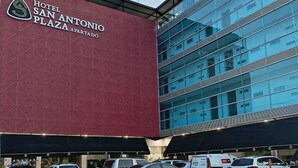A hotel with a large red sign and a modern glass building. - HOTEL SAN ANTONIO PLAZA APARTADO (Apartadó)
