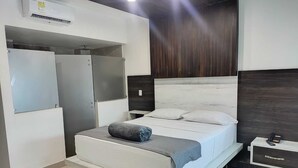 A modern bedroom with a bed, a wardrobe, and a bedside table. - HOTEL SAN ANTONIO PLAZA APARTADO (Apartadó)