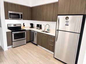 Eine moderne Küche mit Edelstahlgeräten, einer eingebauten Mikrowelle und einem Kühlschrank.