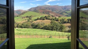 A view of rolling hills and a fenced field through a window. - FAGACHURIA - ITXASSOU (ITXASSOU)