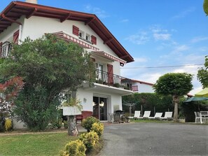 A two-story building with a balcony, a covered outdoor seating area, and a well-maintained lawn. - CHEZ LUBERRIAGA - HASPARREN (HASPARREN)