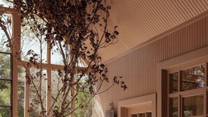Una cocina rústica con ventanas amplias, una mesa de madera y vistas al exterior.