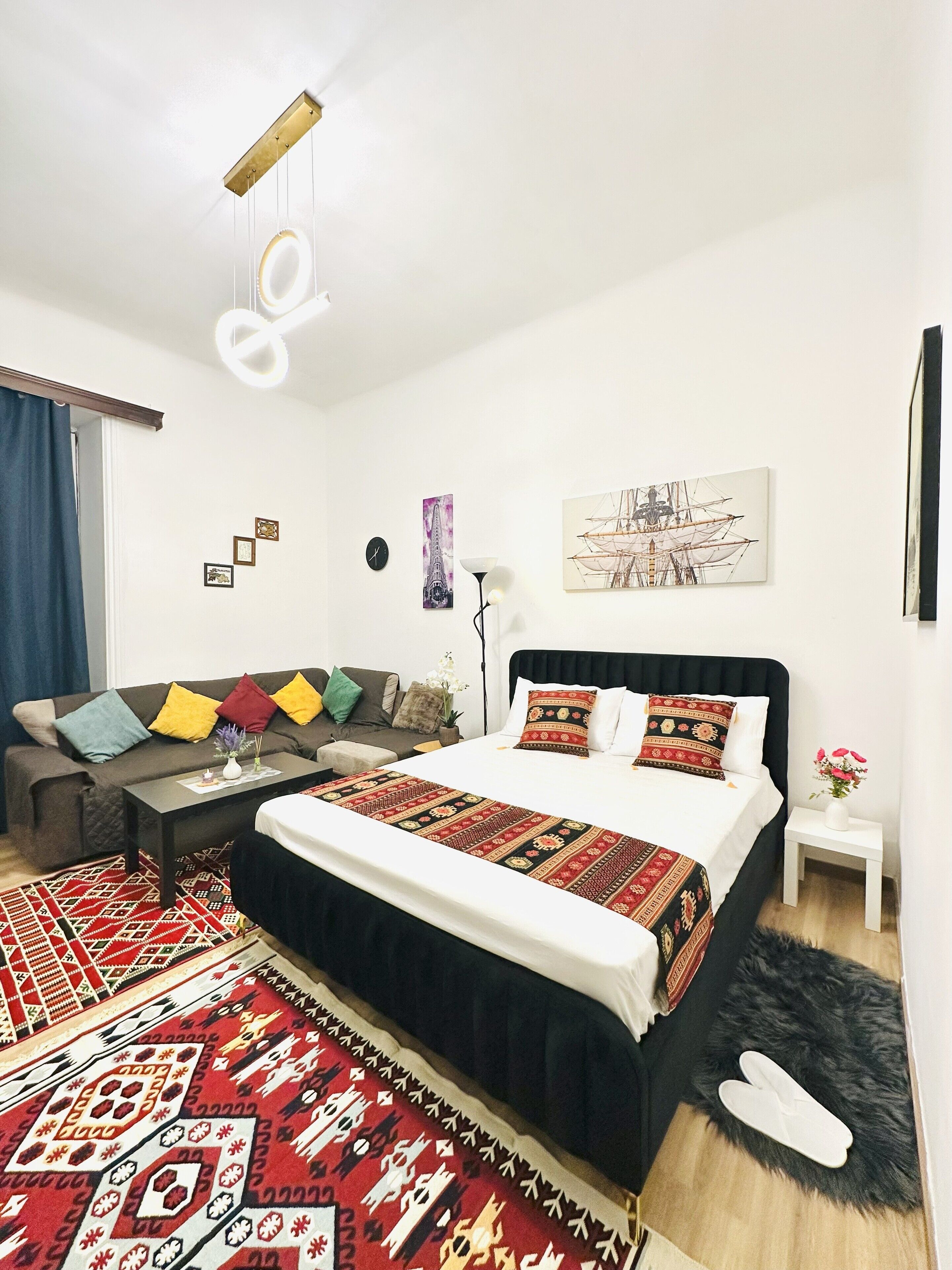 A modern bedroom with a large bed, a sofa, a coffee table, and a rug.