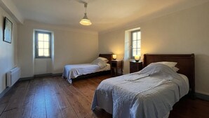 A bedroom with two beds, wooden flooring, and a ceiling fan. - MARTIN AUNDIENIA - SARE (SARE)