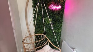 A hanging chair with a cushioned seat and a wooden frame, suspended from a ceiling hook. - Spajungle, a haven of peace and relaxation in the Chevreuse Valley (La Verrière)