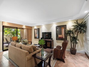 A living room with a sofa, armchairs, a TV, and a potted plant. - Kaanapali Alii 111 | Hot tub | Pool | Sunset Views (Lahaina)