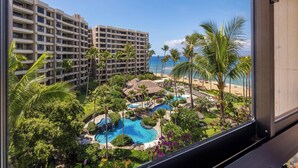 Ein Resort mit einem großen Gebäude, einem Swimmingpool und Blick auf den Strand.