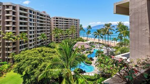 Ein Resort mit Swimmingpool, Palmen und Blick auf Strand und Meer.
