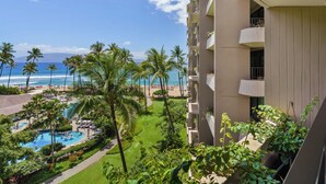 A hotel with a pool, palm trees, and a view of the beach and ocean. - Wake Up With Ocean Views - Professionally Managed (Lahaina)