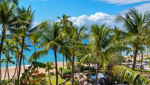 Ein tropisches Resort mit Palmen, einem Strand und einem Wasserfall.