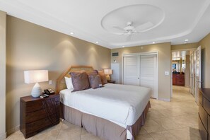 Una camera da letto con un letto grande, un comodino con una lampada, un ventilatore a soffitto e un armadio.