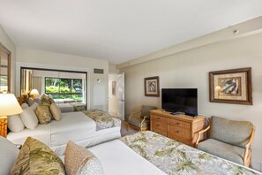 Une chambre d’hôtel avec deux lits, une télévision, une commode en bois et une chaise.