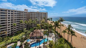 Un hôtel à plusieurs étages, doté d’une piscine et offrant une vue sur la plage.