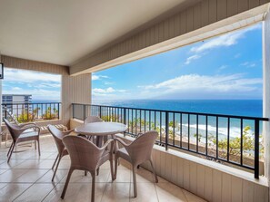 A balcony with wicker furniture, a view of the ocean, and a clear sky. - Front-Row Seats to the Pacific | Oceanfront, Sleeps 6 w/ Resort Amenities (Lahaina)