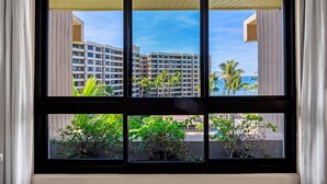 Ein Fenster mit Blick auf hohe Gebäude und Palmen.