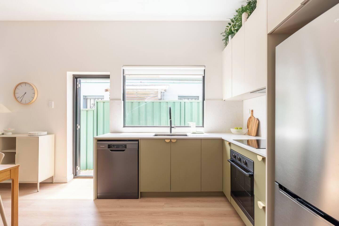 Una cucina moderna dotata di lavastoviglie, fornello e frigorifero.