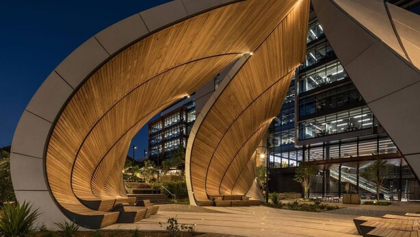 A modern building with curved wooden structures and glass windows. - Stylish Inner-City Terrace Near Green Square (Zetland)
