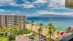 Un hotel con piscina, vista al mar y palmeras.