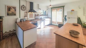 A kitchen with a central island, white cabinets, a gas stove, and a large window.