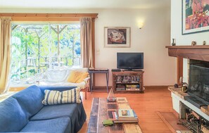 A living room with a sofa, a coffee table, a television, and a fireplace. - Stunning home in Faugères with private swimming pool, can be inside or outside (Faugères)