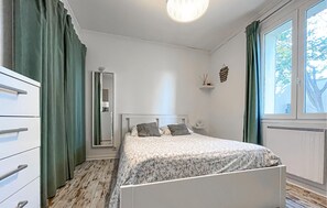 A bedroom with a bed, a dresser, a mirror, and a window with curtains. - Beautiful home in Cabannes (Cabannes)