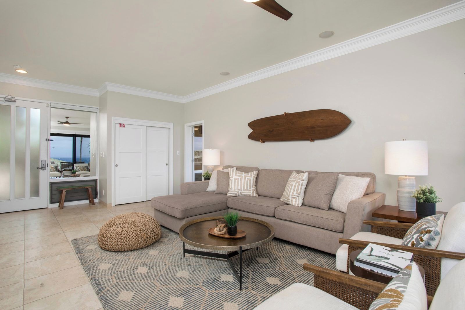 A living room with a sofa, coffee table, and a view of a balcony.