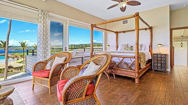 A four-poster bed with a view of the ocean, wicker chairs with cushions, and a ceiling fan. - Kapalua Bay | Ocean View 4 BR, Sleeps 14 | Car Incl. w/ 6+ Nights | KBV ML-2062 by KBM (Lahaina)