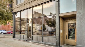 A building with large windows reflecting the cityscape, a door labeled "200", and a sign for "BUFORD LOFTS".