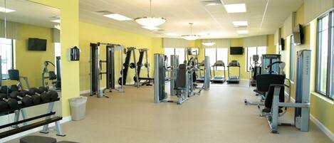 A gym with various exercise equipment, mirrors, and a bench.