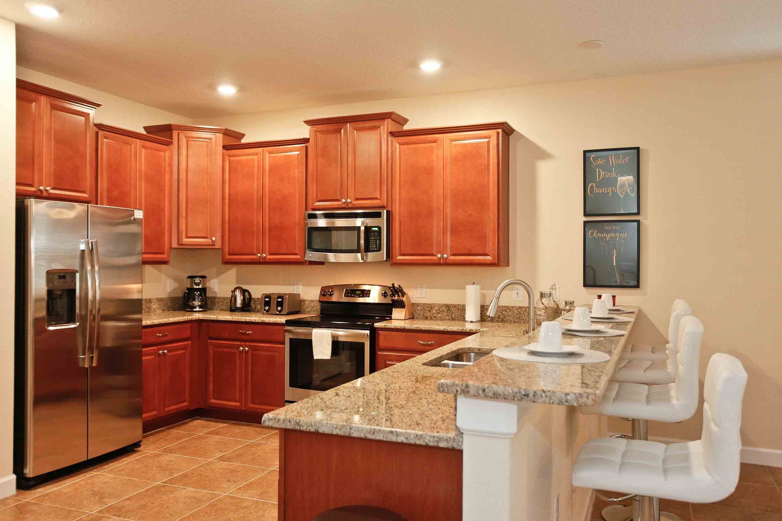 A modern kitchen with wooden cabinets, stainless steel appliances, and a granite countertop.