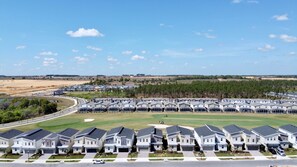 A residential area with modern houses arranged in rows, a golf course, and a clear sky. - Modern Oasis Near Shopping n Golf Course w Pool (Davenport)
