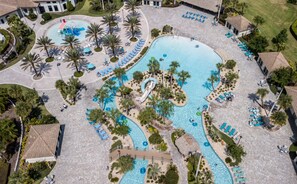 Vue aérienne d’un complexe hôtelier doté de plusieurs piscines, de palmiers et d’espaces de détente.
