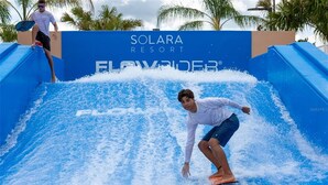 A water slide at Solara Resort with a person surfing. - Perfect for Children With Epic Themed Bedrooms (Kissimmee)
