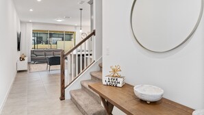Un interior moderno con una escalera que lleva a una sala de estar.