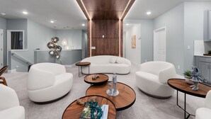A modern living room with a white sofa, two white armchairs, and a coffee table. - Brand New Modern State of the Art Home Sleeps 31 (Kissimmee)