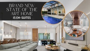 A modern living room with a large grey sectional sofa, black armchairs, a coffee table, and a dining area with chairs and a table. There is a large TV mounted on the wall, and the room has a contemporary design with pendant lighting. - Brand New Modern State of the Art Home Sleeps 31 (Kissimmee)