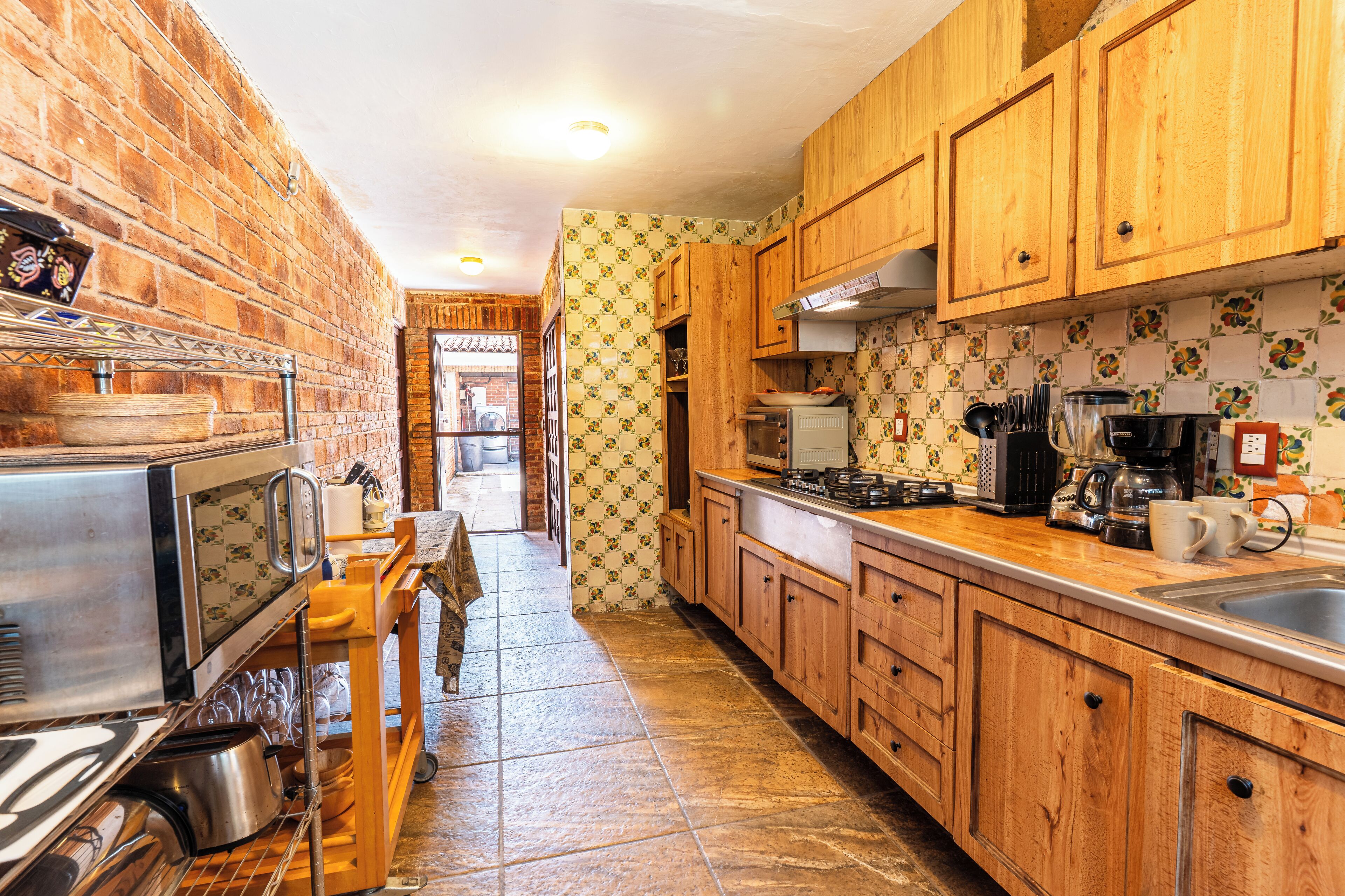 A kitchen with wooden cabinets, a stainless steel refrigerator, and a tiled backsplash.