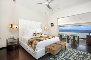 A modern bedroom with a large bed, a bench, a desk, and a view of the ocean. - Kapalua Bay | Ocean View 4 BR, Sleeps 12 | Car Incl. w/ 6+ Nights | KBV ML-2077 by KBM (Lahaina)