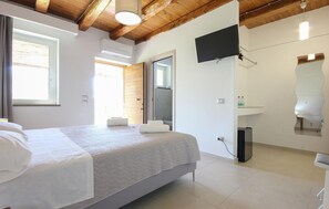 A bedroom with a bed, a television, a bathroom with a mirror, and a shower. - Stunning home in Perdifumo with house a panoramic view (Perdifumo)